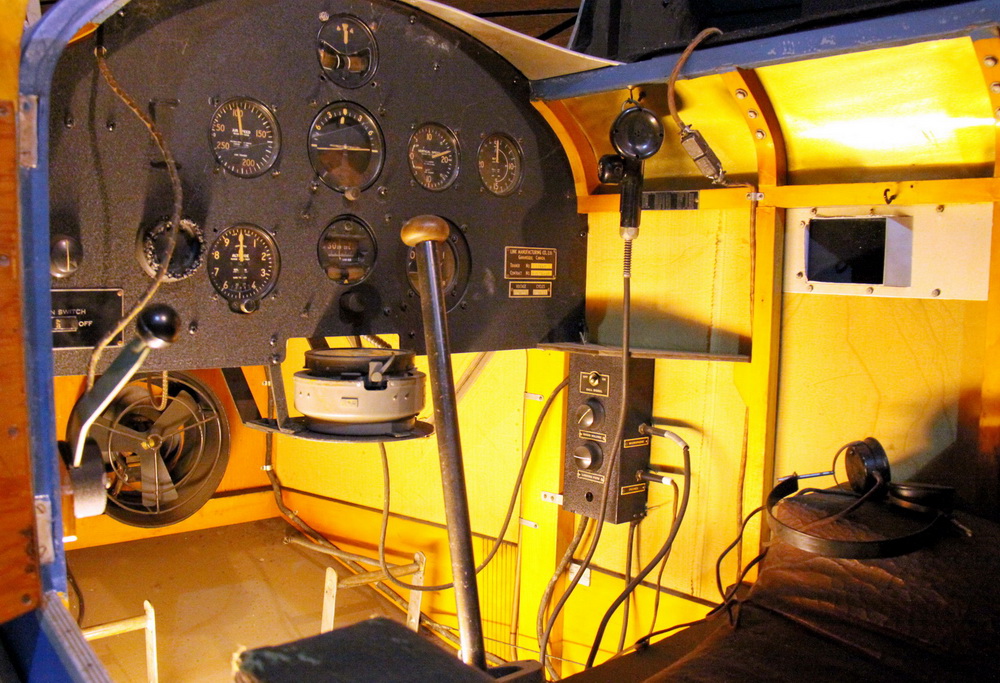 Link Trainer
- letecký trenažér / Kanada 1940.
V trenažéru jsou umístěny ovladače přípusti motoru,držák palubních hodin, ruční a nožní řízení, spojovací skříňka radia. Z přístrojů jsou vidět rychloměr, výškoměr, zatáčkoměr, umělý horizont, vodorovný kompas, variometr, ukazatel ILS, otáčkoměr. Na dalším záběru je ovládací stůl instruktora se záznamem letěné trasy.
