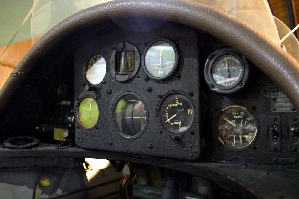 Pohled do zadního pilotního prostoru, ve kterém se nalézají přepínač magnet, výškoměr, kulový kompas, zatáčkoměr, rychloměr, umělý horizont variometr, otáčkoměr a sdružený ukazatel teploty a tlaku oleje a tlaku paliva.