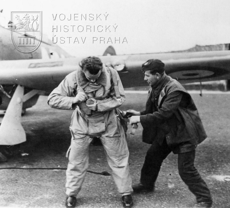 Mechanik pomáhá P/O Václavu Bergmanovi (* 27. 8. 1915, Domoušice, okr. Louny, † 31. 12. 2002, Dumbarton, Skotsko) do padákového postroje. První boj 310. peruti odpoledne 26. srpna 1940 byl pro něj tvrdou lekcí z letecké taktiky. Padák Irvin mu zachránil život.
