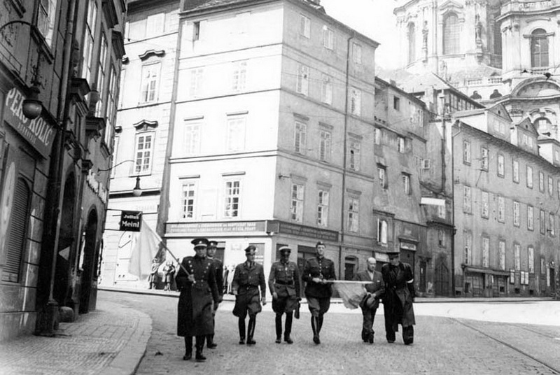 Zdeněk Vltavský (třetí zprava) vede jako parlamentář 8. května 1945 Karmelitskou ulicí německého generála Rudolfa Toussainta na velitelství Bartoš k podpisu německé kapitulace v Praze

