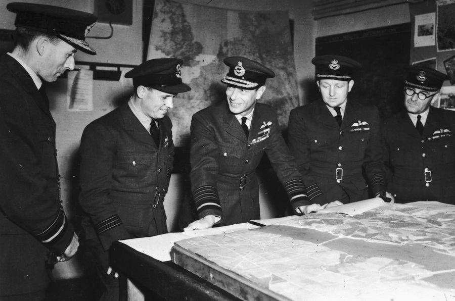 Air Vice Marshal Ralph Cochrane, Wing Commander Guy Gibson, král Jiří VI. a Group Captain John Whitworth diskutují 27. května 1943 o operaci CHASTISE na velitelství 5. skupiny Bomber Command v Granthamu.
FOTO: RAF Museum
