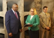 V kryptě památníku. Americký ministr obrany Lloyd Austin, ministryně obrany Jana Černochová a náčelník Generálního štábu AČR, generálmajor Karel Řehka. Jana Černochová s knihou Assassination (Atentát), kterou vydal VHÚ. Foto: Tomáš Novák, Karel Šanda.