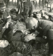 Atmosféra okamžiku po střetu s henleinovskými vzbouřenci ze září 1938. Zdravotníci Stráže obrany státu ošetřují raněného člena vojenským posil. FOTO: VÚA‒VHA 

 