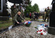 Ljuklanivský hřbitov - ministryně obrany Jana Černochová upravuje stuhu na smutečním věnci. Foto: Jan Schejbal