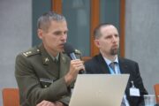 S mikrofonem hovoří pplk. JUDr. PhDr. Stanislav Polnar, Ph.D.z Fakulty vojenského leadershipu Univerzity obrany na téma: "Rok 1945 a Benešova koncepce právní kontinuity", za ním hledí do publika Doc. PhDr. Pavel Mücke, Ph.D., z Ústavu pro soudobé dějiny AV ČR a VHÚ Praha. Konference "1945-Nové pohledy". Armádní muzeum Žižkov, Praha, 20, 5, 1945, FOTO Jiří Reichl, VHÚ Praha